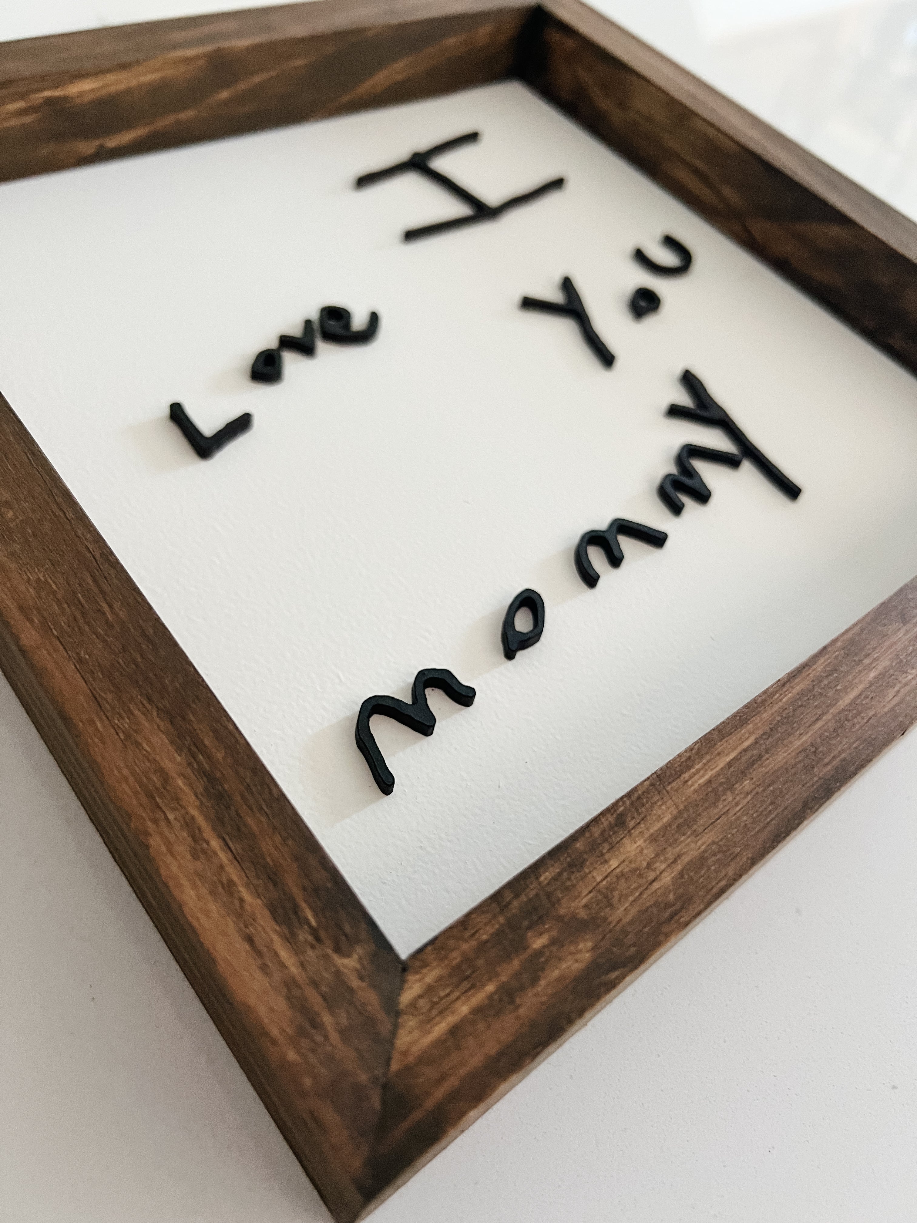 Wooden frame with 'I Love You Mommy' text on a white background