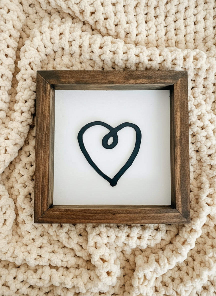 Framed heart artwork on a textured beige surface
