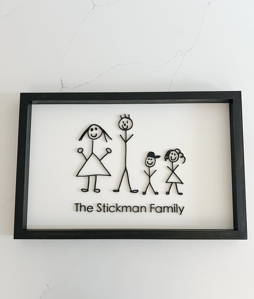 Framed artwork of a family with stick figures on a white background