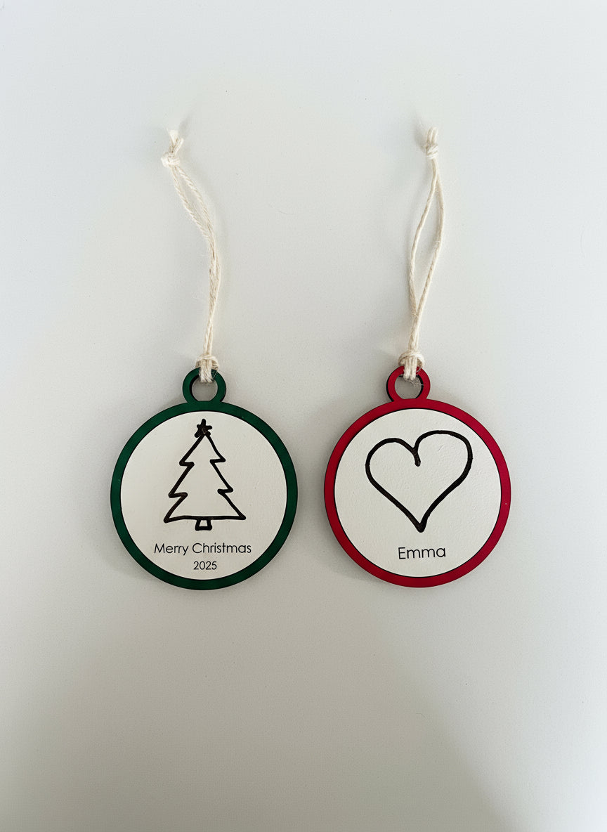 Two round Christmas ornaments with tree and heart designs on a white background