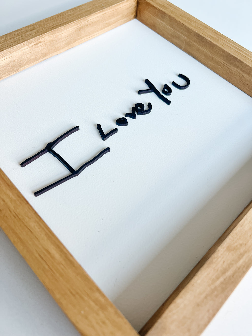 Wooden frame with 'I Love You' text on a white background